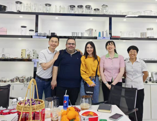 Zhongshan Yuekon Electrical Appliances Co., Limited representatives standing with international clients, demonstrating strong business relationships.