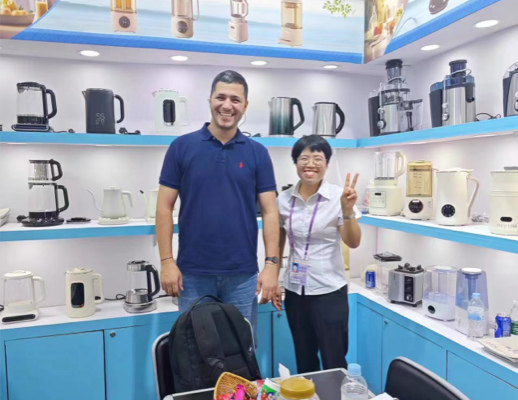 Image of Zhongshan Yuekon Electrical Appliances Co., Limited team members and international clients smiling for a group photo, reflecting a positive business interaction.