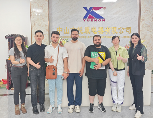 Zhongshan Yuekon Electrical Appliances Co., Limited employees and international clients posing together, symbolizing a successful and collaborative business relationship.